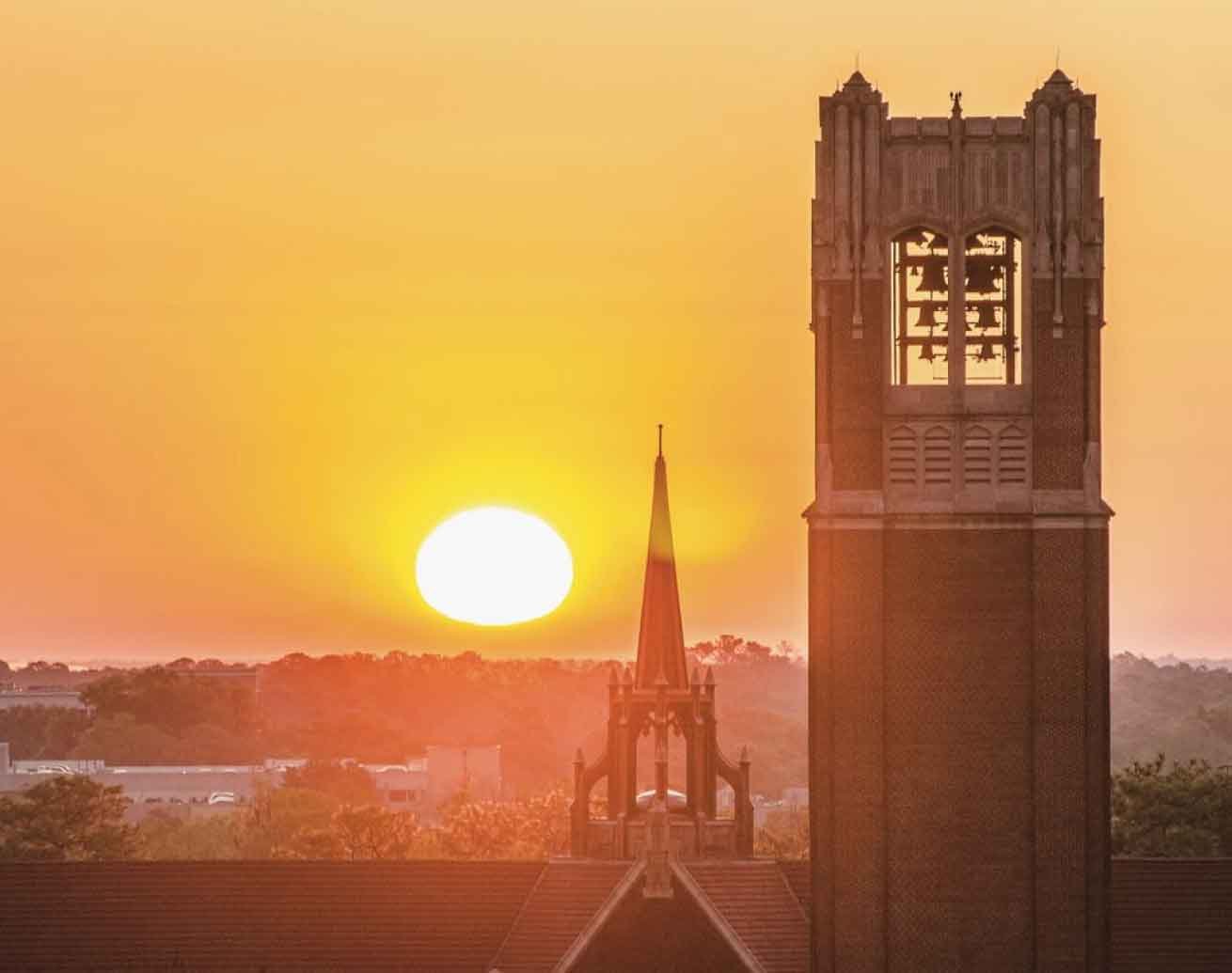 brick bell tower and spire at sunset